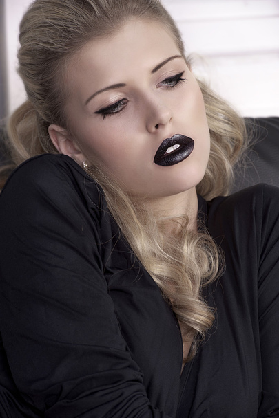 Blond girl on sofa with black lips - Foto, Imagen