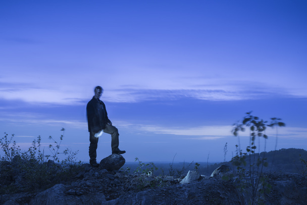 Silhouette of a man black on the night blue sky among the rocks - Φωτογραφία, εικόνα