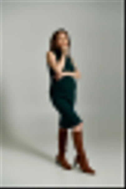 Молодая беременная женщина излучает элегантность в ярко-зеленом платье, когда она позирует для портрета. - Фото, изображение