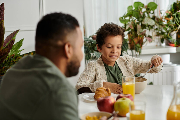 Man en vrouw, Afro-Amerikaans, samen ontbijten aan tafel. - Foto, afbeelding