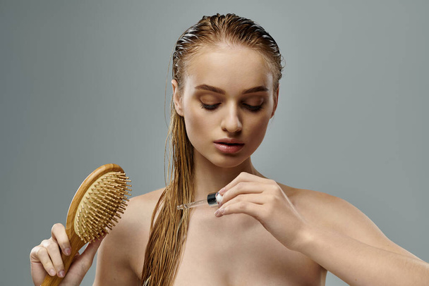Mladá žena s dlouhými mokrými vlasy pomocí štětce. - Fotografie, Obrázek