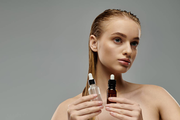 Una joven hermosa mujer mostrando su rutina de cuidado del cabello, sosteniendo una botella de aceite nutritivo para el cabello. - Foto, imagen