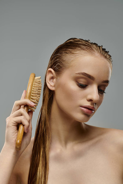 Eine junge Frau mit nassen Haaren präsentiert ihre Haarpflege-Routine, indem sie ihre langen Locken streicht. - Foto, Bild