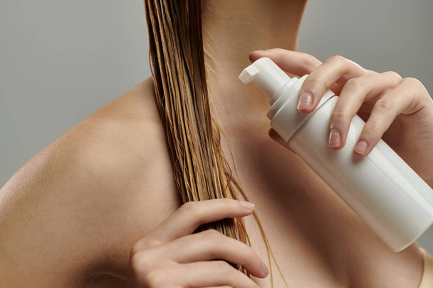 Молодая женщина применяет лечение волос. - Фото, изображение