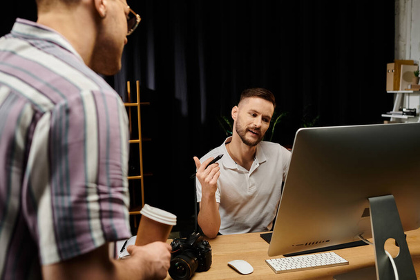 Hombre en un entorno de oficina moderno, centrado en el trabajo de computadora, hablando con su pareja gay. - Foto, Imagen