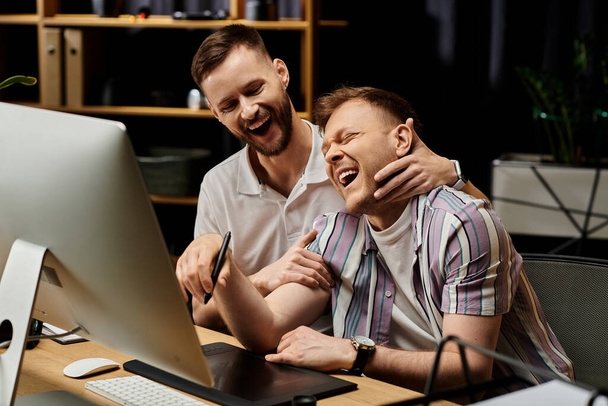 İki adam, günlük giysiler içinde, bilgisayarın önünde birlikte oturuyorlar.. - Fotoğraf, Görsel
