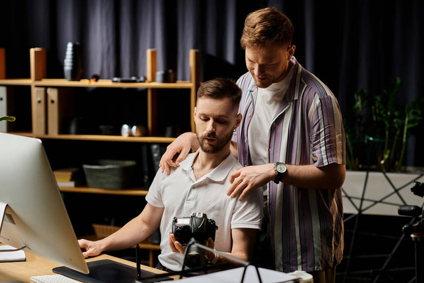 Két férfi alkalmi ruhában, egy számítógép képernyőjére fókuszálva, irodai környezetben.. - Fotó, kép