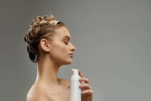 Κομψή γυναίκα κρατώντας μπουκάλι σπρέι, φροντίδα για βρεγμένα μαλλιά. - Φωτογραφία, εικόνα