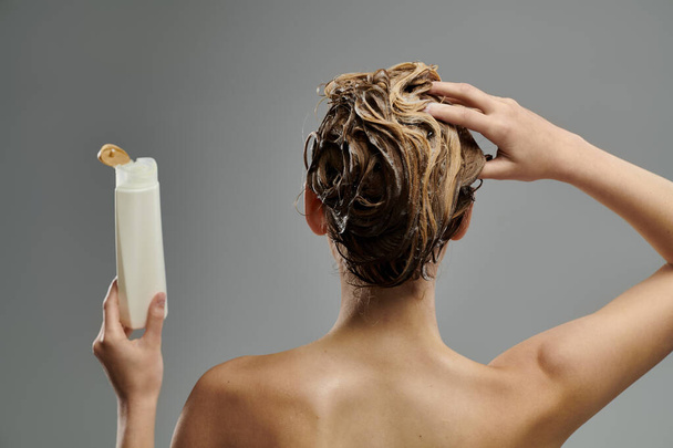 Woman holding a tube of shampoo. - Fotografie, Obrázek