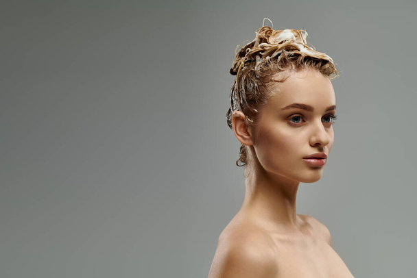 Giovane donna dimostra routine di cura dei capelli con i capelli bagnati. - Foto, immagini