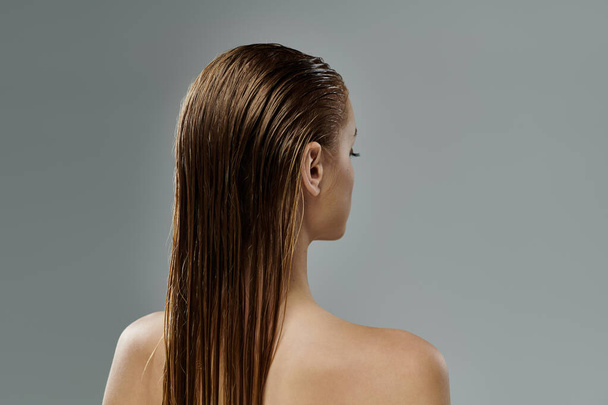 Eine Frau enthüllt ihre langen, nassen Haare. - Foto, Bild