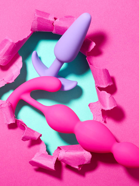 giocattolo del sesso su foro in sfondo di carta rosa - Foto, immagini