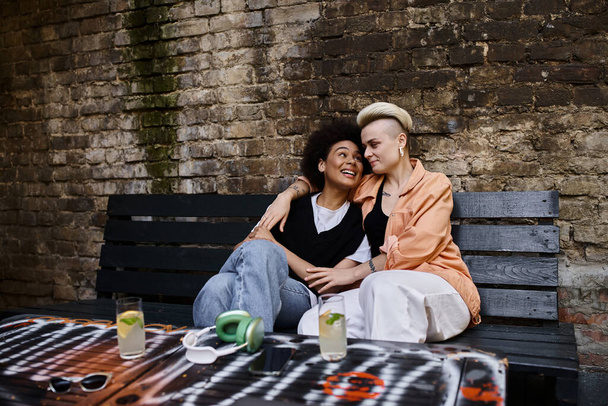 Two women embracing on a rustic wooden bench. - Photo, Image