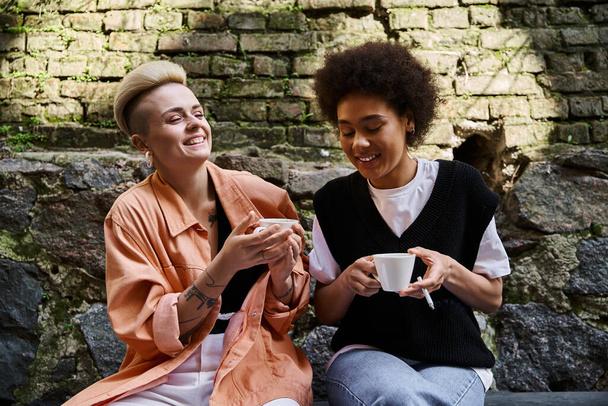 Un par de lesbianas diversas y hermosas disfrutando de una cita en un acogedor café. - Foto, Imagen