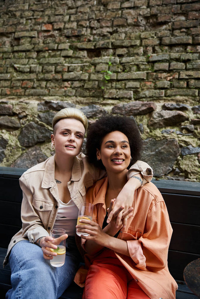 Néhány leszbikus együtt iszik egy padon egy kávézóban.. - Fotó, kép