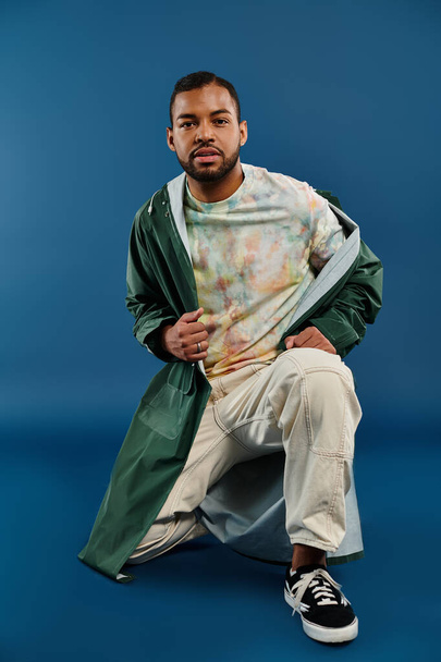 Een stijlvolle Afro-Amerikaanse man zit stoutmoedig in een levendige groene jas. - Foto, afbeelding