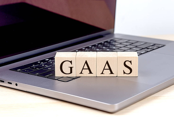 GAAS-Wort auf Holzklotz auf Laptop, Geschäftskonzept.  - Foto, Bild