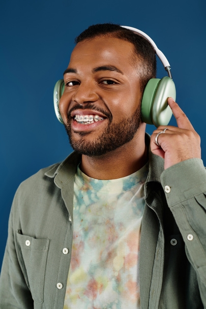 Χαμογελώντας άνθρωπος με ακουστικά σε ζωντανό φόντο. - Φωτογραφία, εικόνα