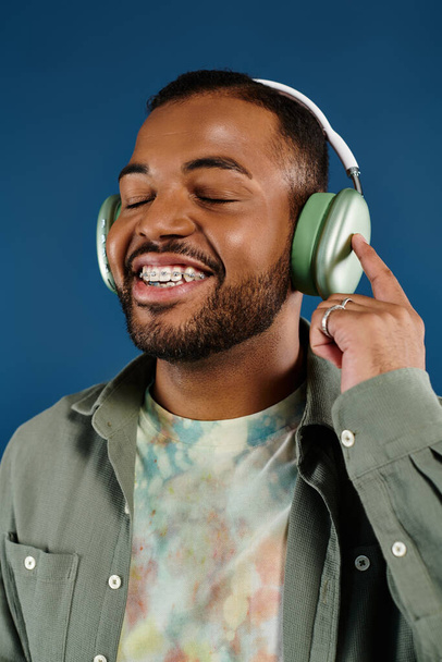 Homem afro-americano elegante sorrindo, usando fones de ouvido. - Foto, Imagem