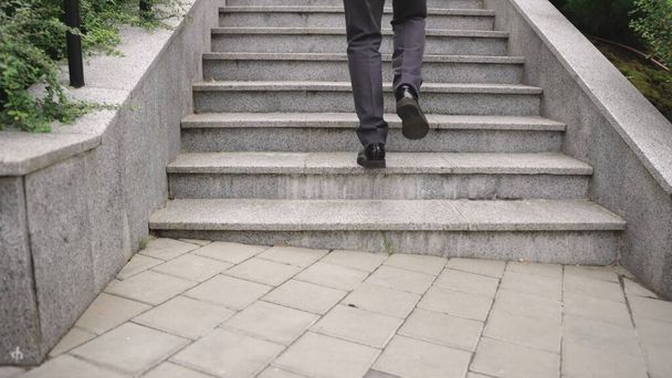 Бизнесмен поднимается по лестнице на улицу. Обрезан. Бизнес, концепция людей. Медленное движение - Фото, изображение