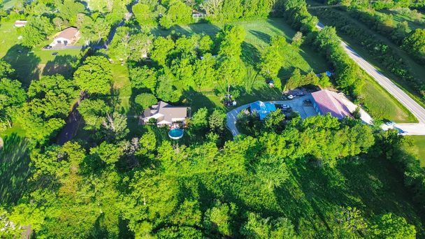 Lush greenery tree surrounding large farm houses with portable pop-up swimming pool near country road in Mountain Grove Missouri, farmland ranches in the Midwest, agricultural area, aerial view. USA - Foto, immagini