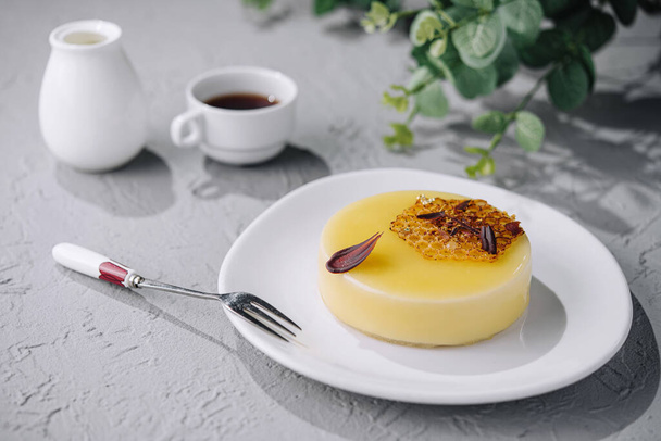 Складний десерт з кремовим фланцем з карамеллю та гарніром на білій тарілці - Фото, зображення