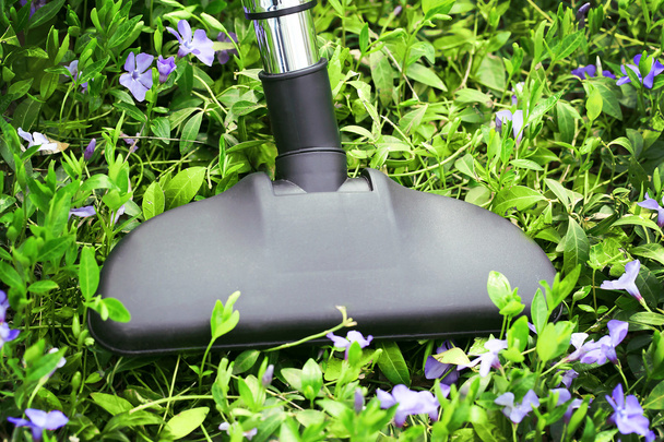 Metal pipe of vacuum cleaner in action - clean carpet of real green grass. Ecology concept  - Foto, imagen