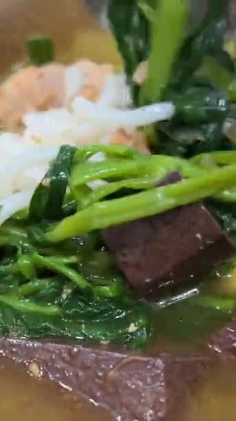 Яловичий суп з крові шматочки крові в супі азіатської їжі зі скляною вермішель. овочі зі шпинату - Кадри, відео