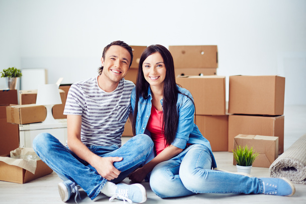 Άνδρας και γυναίκα κάθεται στο πάτωμα του καινούριο διαμέρισμα - Φωτογραφία, εικόνα