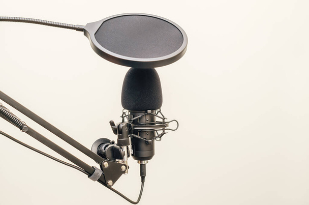 Μικρόφωνο στούντιο σε ένα περίπτερο σε ένα ελαφρύ φόντο - Φωτογραφία, εικόνα