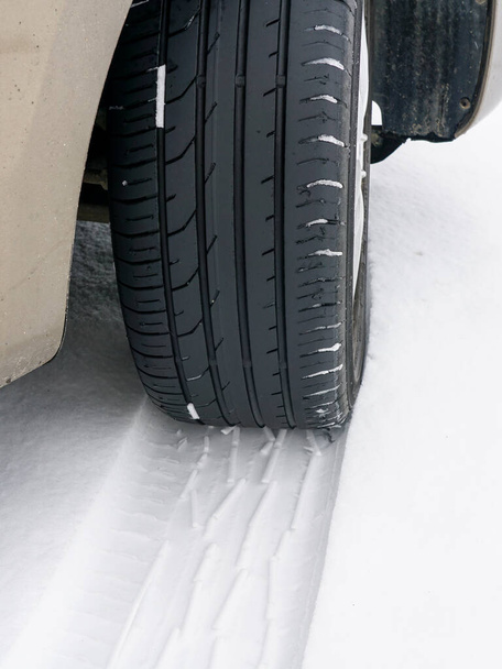 冬季の滑りやすい雪道を走行中の安全でない夏のトレッドタイヤを搭載した車輪,雪の夏タイヤ - 写真・画像
