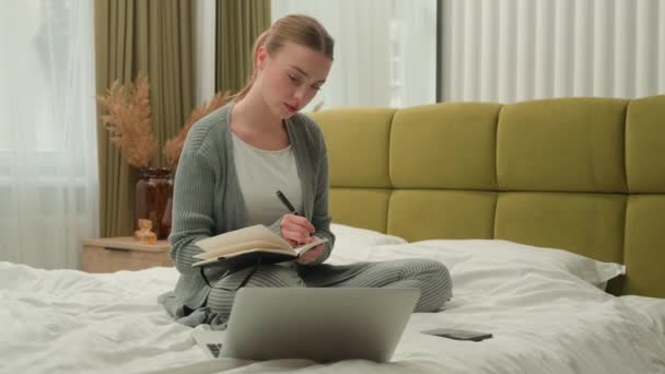 Caucasian student girl home education e-learning teenager female freelancer business woman at bedroom on bed writing notes study learning watching webinar class lesson online laptop write test prepare - Кадри, відео