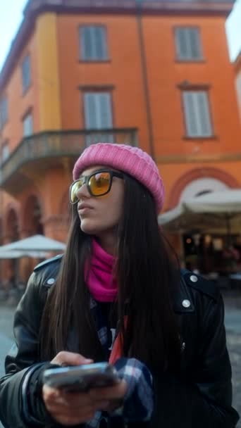 彼女の携帯電話を持つトレンディな若い女性は,ヨーロッパの街路を散策します. 高品質の4k映像 - 映像、動画