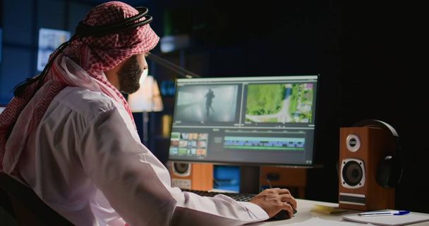 Arabic colorist freelancer editing outsourcing cinematographic project, creating content creation stock footage, working with images and sounds. Teleworking worker processing movie on PC workstation - Photo, Image