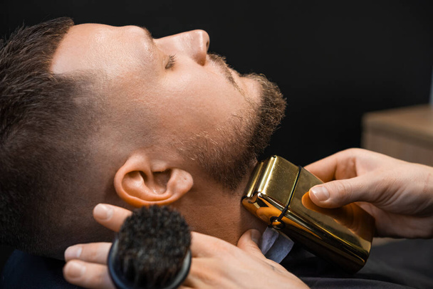 Client during beard trimming in the barbershop. - Foto, Bild