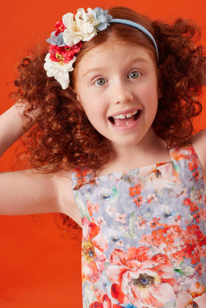 Smiling Redhead Girl with Freckles in Blue Floral Dress on Orange Background - Fotoğraf, Görsel