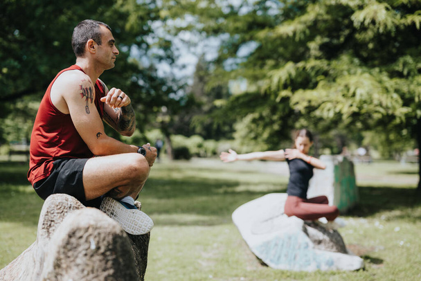 Ein Mann und eine Freundin machen Yoga-Übungen in einem üppig grünen Park und demonstrieren Konzentration und Teamwork. - Foto, Bild