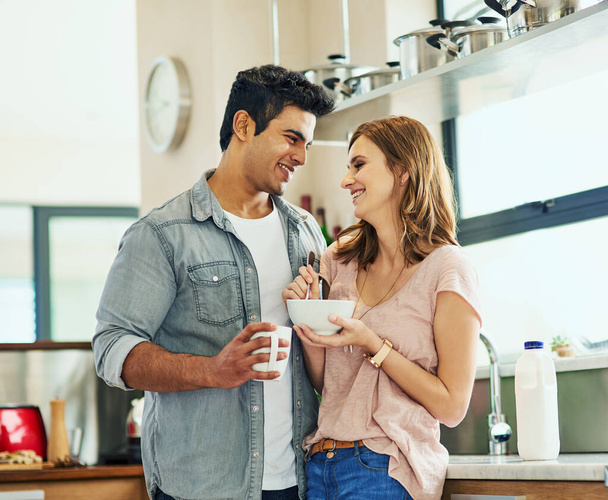 Couple, breakfast and love in house with hug for relationship, date and time together in living room. Man, woman and support with happiness, tea and smile in home for connection, care and commitment. - Photo, Image