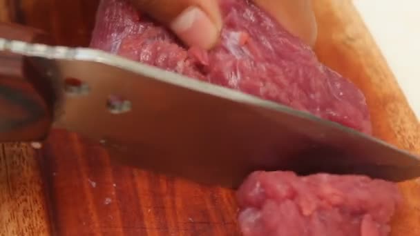 rebanar carne de res en una tabla de cortar de madera con un cuchillo afilado. adecuado para temas de cordero y carne de vacuno. - Metraje, vídeo