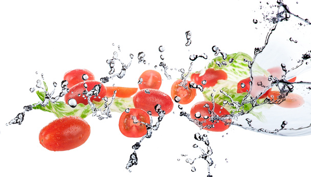 Salat mit Tomaten auf weißem Hintergrund und Spritzwasser - Foto, Bild
