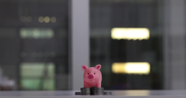 Pink piggy bank on a stack of growing silver coins. Increased profits and profitable cash investments - Metraje, vídeo