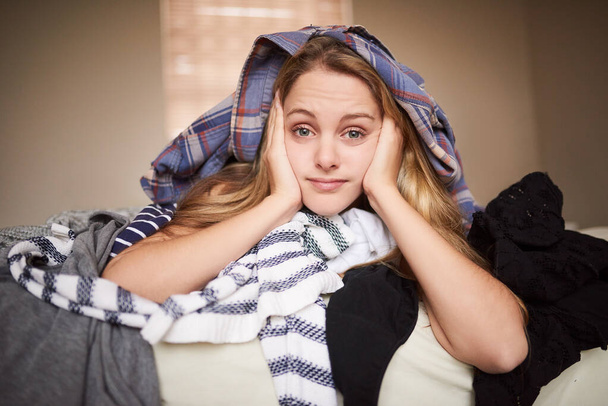 Housekeeping, portrait and woman with laundry pile for home chores with bored in bedroom. Face, tired and housewife on bed with dirty clothes, bedding or linen for washing with hygiene at apartment - Fotoğraf, Görsel