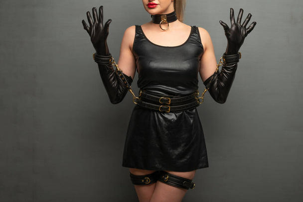 Beautiful young woman in a leather dress and bondage set posing - Foto, immagini