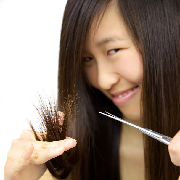 Onnellinen aasialainen tyttö leikkaus split umpikujia hiukset
 - Valokuva, kuva
