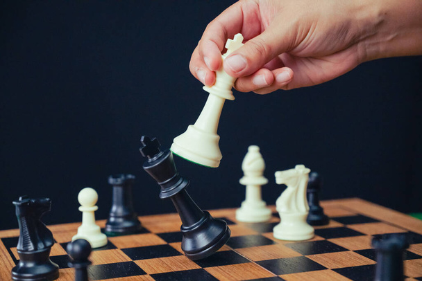 チェスボードはチェックメイトの決定的な瞬間を捉え,ビジネスコンテキストにおける戦略的勝利を象徴しています. イメージは,戦略的な計画,批判的な意思決定,そして競争的な成功のテーマを伝えます. - 写真・画像