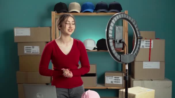 Vrouw opnemen van een DIY hoed opslag organisatie vlog in een home studio met ring licht en karton dozen. - Video