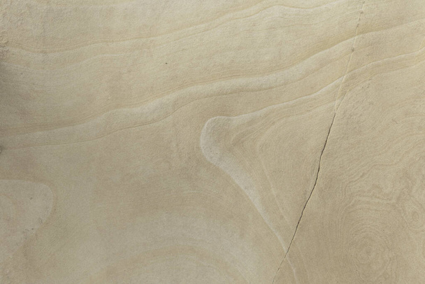 Close-up of a smooth sandstone surface featuring subtle natural patterns and textures. Perfect for backgrounds, nature themes, and geological studies. - Foto, Bild