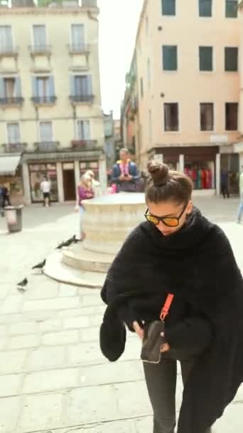 Egy divatos fiatal barna felfedezni az utcákat Velence, lenyűgözte a szépség. Kiváló minőségű 4k felvételek - Felvétel, videó