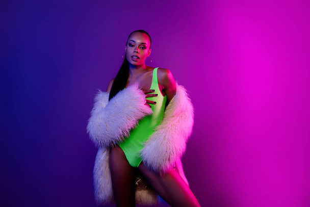 Foto von hübschen ästhetischen Modell Mädchen posiert Pelzmantel Körper isoliert auf Farbverlauf Neon Hintergrund. - Foto, Bild