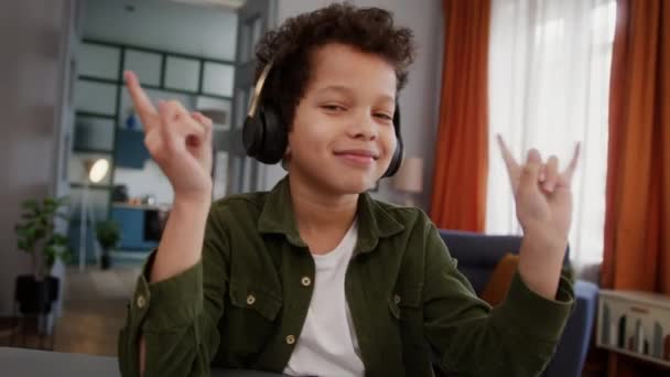 Happy smiling African American custody adopted child boy little kid son smile positive enjoying rock song sound listening music in headphones earphones dancing hands moving listen track funny at home - Filmati, video